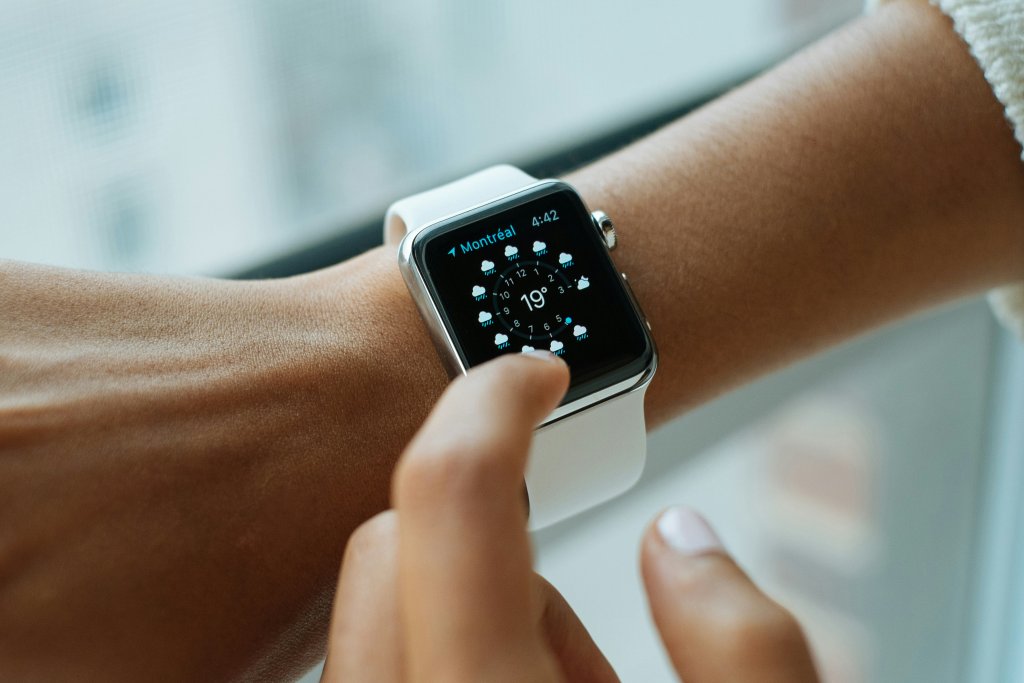Osoba použ&iacute;vaj&iacute;c&iacute; Apple Watch s b&iacute;l&yacute;m řem&iacute;nkem při kontrole počas&iacute; na obrazovce. Detail dotykov&eacute;ho ovl&aacute;d&aacute;n&iacute; na chytr&yacute;ch hodink&aacute;ch od společnosti Apple. Ide&aacute;ln&iacute; pro čl&aacute;nky o oprav&aacute;ch dotykov&yacute;ch obrazovek Apple Watch a př&iacute;slu&scaron;enstv&iacute;.