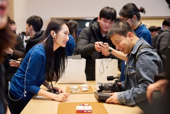 Členové týmu Apple v Apple Hongdae pomáhají zákazníkům s nákupem.