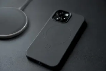 Telefon v černém magnetickém pouzdře vedle nabíječky