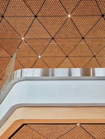 Zleva doprava: (1) Trojúhelníkový ručně vyrobený dřevěný strop přesahuje skleněnou fasádu až na spodní stranu vnějšího přístřešku a odráží jedinečnou geometrii obchodu. (2) Každá deska je vyrobena ze 408 kusů dřeva, což tvoří 31 modulů na desku s cel