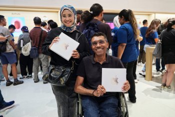 Zákazníci se na otevření Apple The Exchange TRX chlubí svým zbožím.